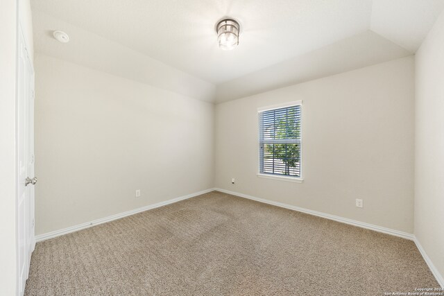 unfurnished room featuring vaulted ceiling and carpet flooring