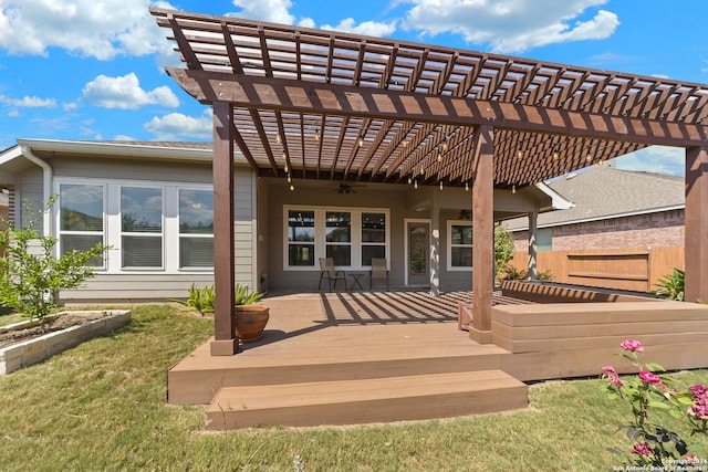 back of house with a wooden deck, a pergola, a lawn, and ceiling fan