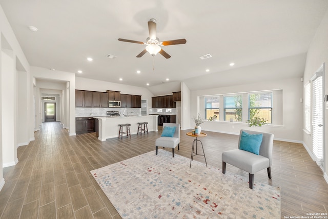 living room with ceiling fan and vaulted ceiling