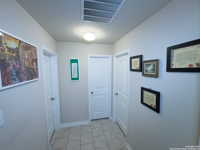 hall featuring light tile patterned floors