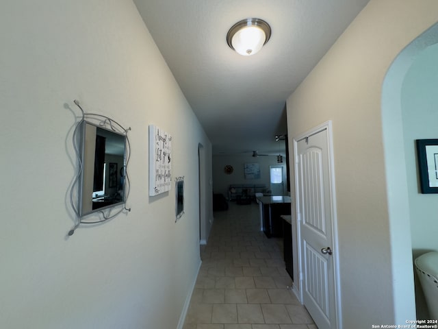 hallway featuring electric panel and light tile patterned flooring