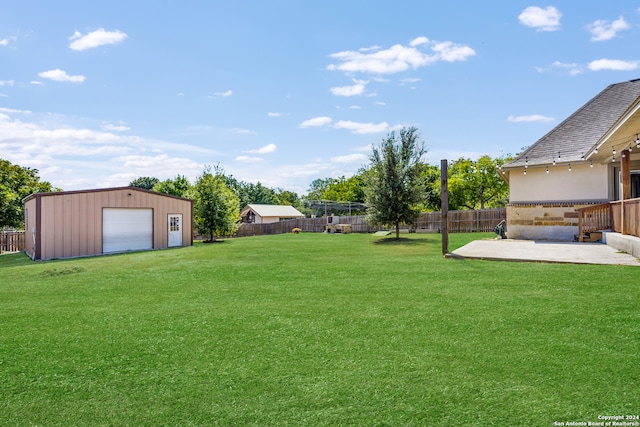 view of yard with an outdoor structure, a garage, and a patio area