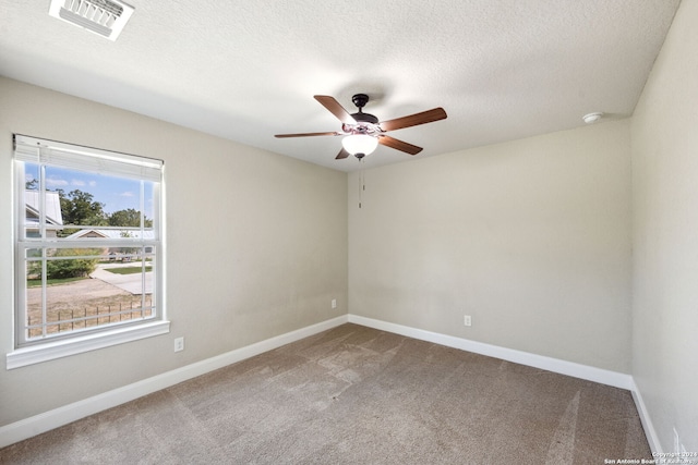 spare room with ceiling fan, a textured ceiling, and carpet flooring