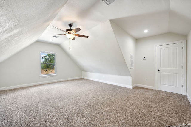 bonus room featuring a textured ceiling, carpet, vaulted ceiling, and ceiling fan