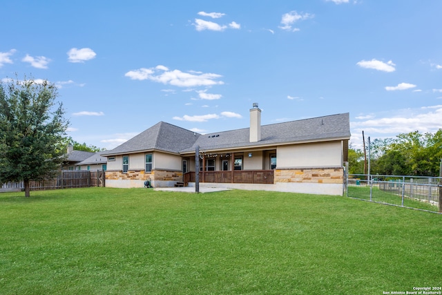 rear view of property featuring a lawn and a patio area