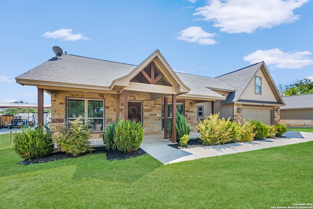 view of front of property with a porch, a garage, and a front yard