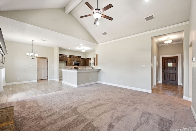 unfurnished living room featuring light colored carpet, beamed ceiling, ornamental molding, and high vaulted ceiling