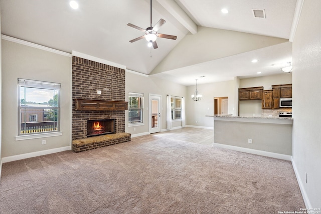 unfurnished living room with ceiling fan with notable chandelier, a fireplace, light carpet, high vaulted ceiling, and ornamental molding