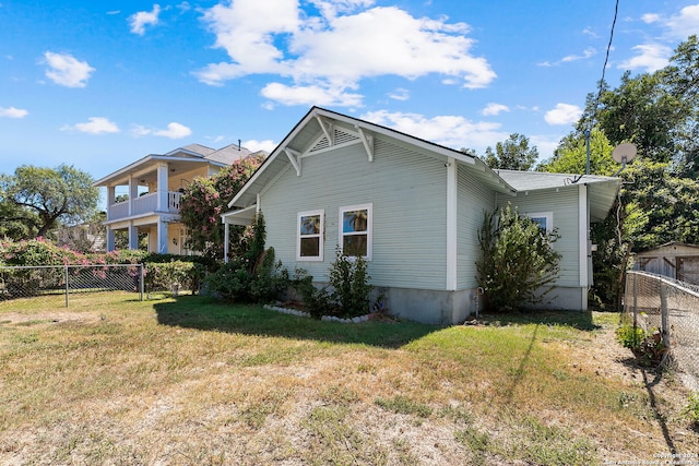 view of side of property featuring a lawn and fence