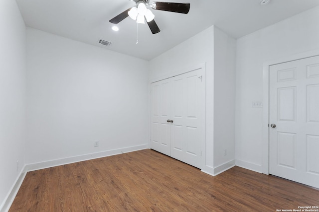 unfurnished bedroom with ceiling fan, a closet, and dark hardwood / wood-style floors