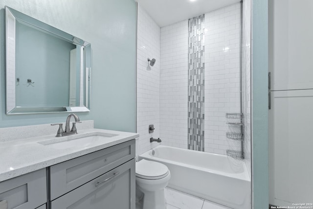 full bathroom featuring tiled shower / bath, vanity, and toilet