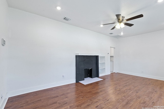 unfurnished living room with baseboards, a ceiling fan, wood finished floors, and visible vents