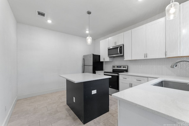 kitchen featuring stainless steel appliances, backsplash, visible vents, a sink, and a kitchen island