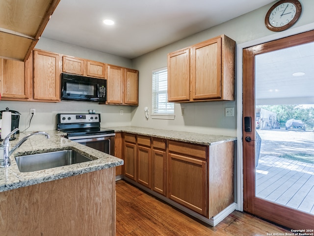 kitchen featuring electric stove, light stone counters, sink, and dark hardwood / wood-style flooring