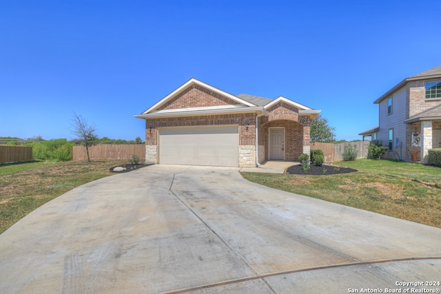 single story home featuring a front lawn and a garage