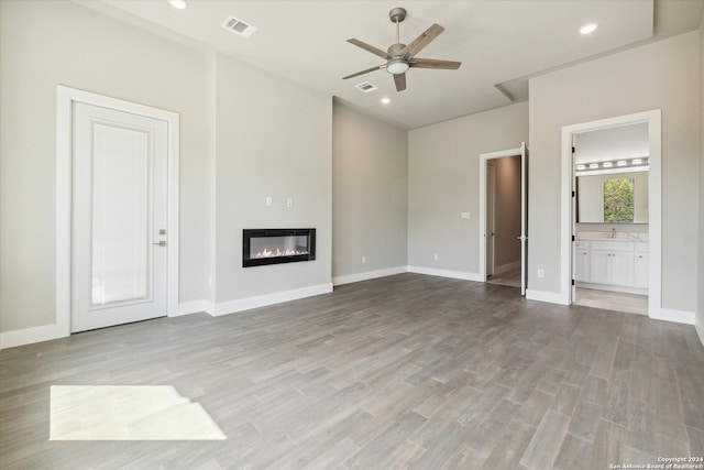 unfurnished living room featuring sink, light hardwood / wood-style flooring, and ceiling fan