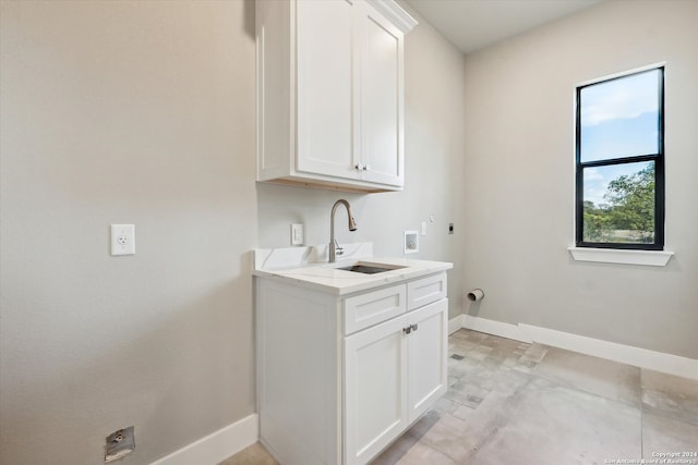 clothes washing area with cabinets, hookup for a washing machine, sink, and electric dryer hookup