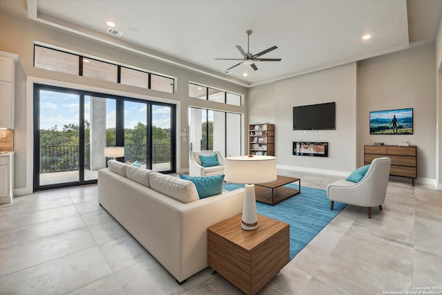 tiled living room featuring a high ceiling and ceiling fan