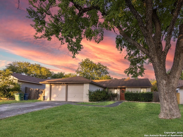 ranch-style home featuring a yard and a garage