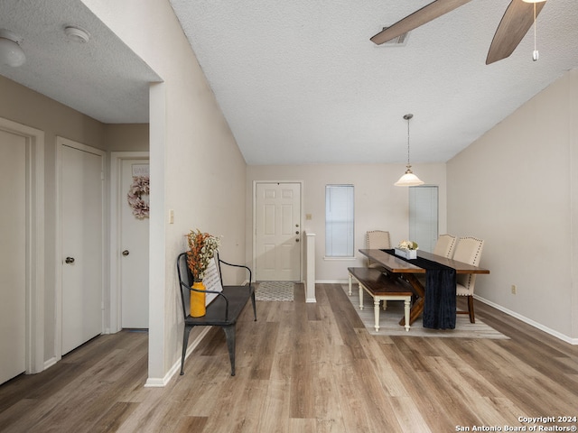 dining room with ceiling fan, a textured ceiling, and light hardwood / wood-style flooring