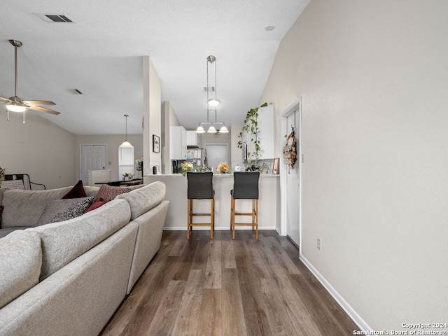 living room with lofted ceiling, dark hardwood / wood-style flooring, and ceiling fan