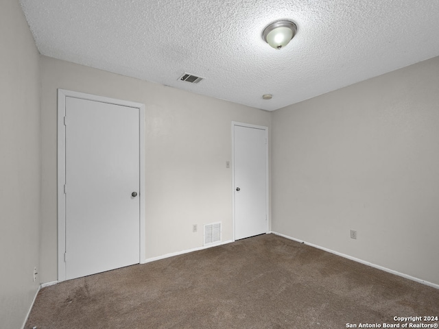 carpeted spare room featuring a textured ceiling