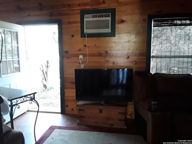 living room featuring wood walls and a wall mounted air conditioner