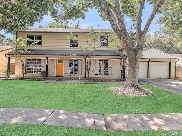 view of property featuring a front lawn, covered porch, and a garage