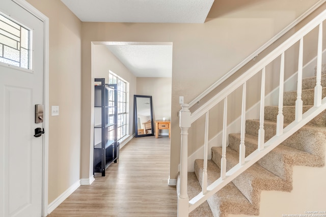 foyer entrance featuring a textured ceiling and hardwood / wood-style flooring