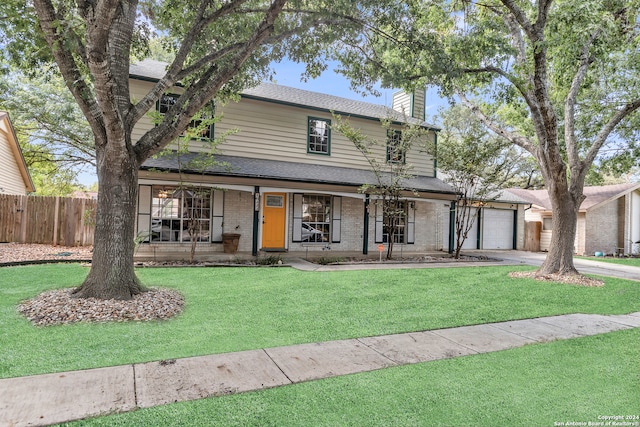 view of front of house with a porch, a garage, and a front lawn