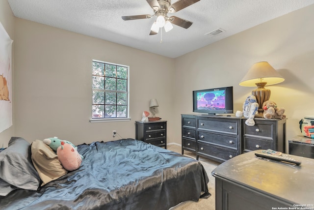 carpeted bedroom with ceiling fan and a textured ceiling