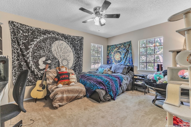 carpeted bedroom with a textured ceiling and ceiling fan