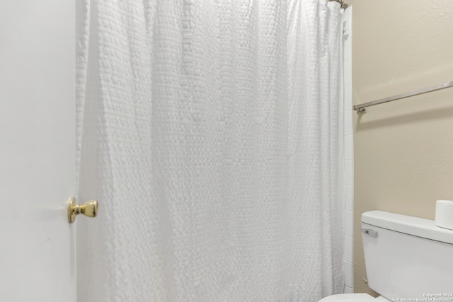 bathroom with a shower with curtain and toilet