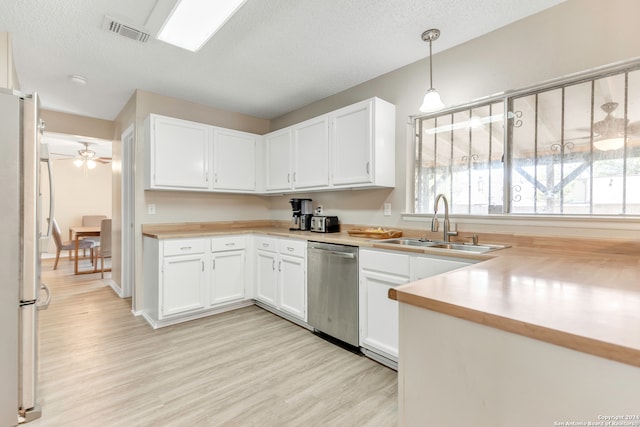 kitchen with stainless steel appliances, white cabinetry, and hanging light fixtures