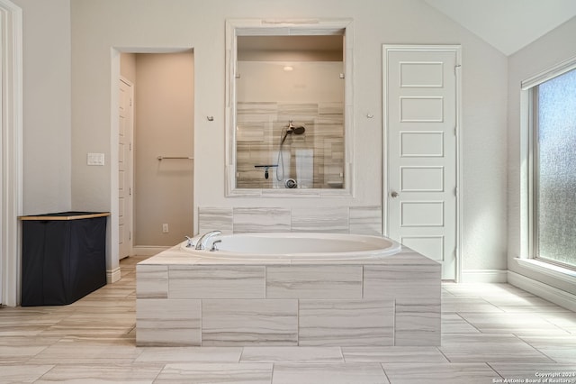 bathroom with shower with separate bathtub and lofted ceiling