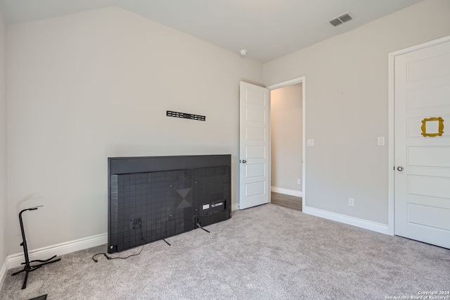 unfurnished bedroom with vaulted ceiling and light colored carpet