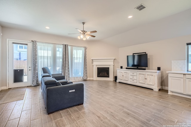 living room featuring vaulted ceiling, ceiling fan, and light hardwood / wood-style flooring