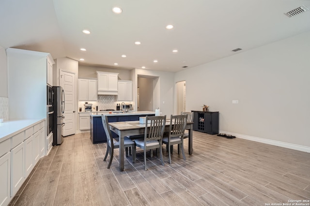 dining space with light wood-type flooring and sink