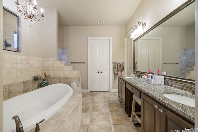 bathroom with vanity, tile patterned flooring, a chandelier, and a relaxing tiled tub