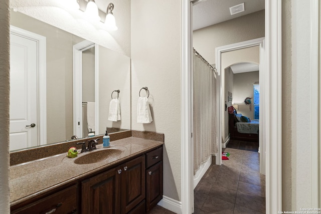 bathroom with a shower with curtain, vanity, and tile patterned floors