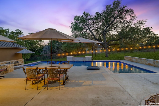 pool at dusk featuring a patio