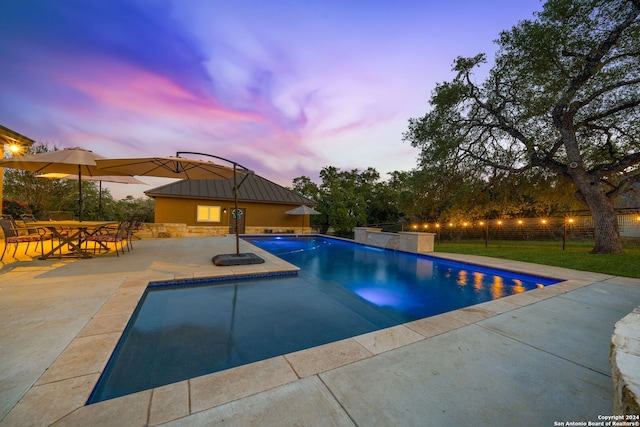 pool at dusk with a patio