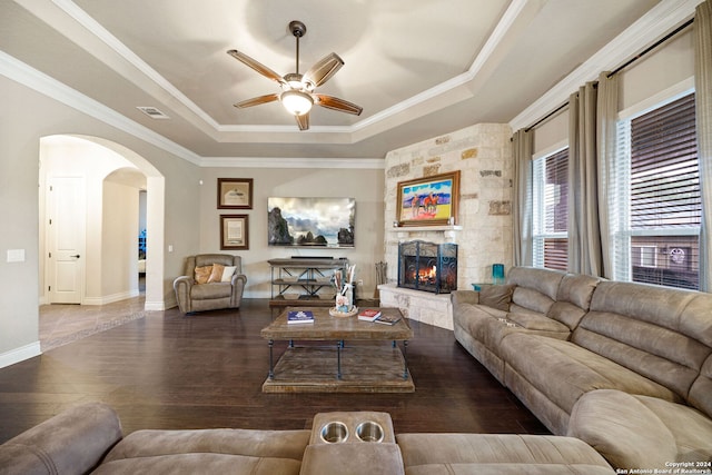 living room featuring ornamental molding, a raised ceiling, a fireplace, and dark hardwood / wood-style flooring