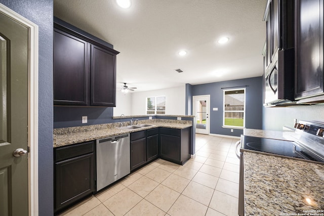 kitchen with sink, kitchen peninsula, appliances with stainless steel finishes, light tile patterned floors, and light stone countertops