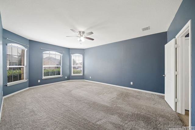 spare room featuring ceiling fan and carpet flooring