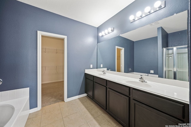 bathroom with plus walk in shower, tile patterned flooring, and vanity