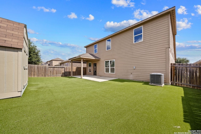 rear view of house featuring a lawn, cooling unit, and a patio area