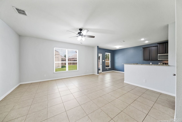 unfurnished living room with light tile patterned floors and ceiling fan