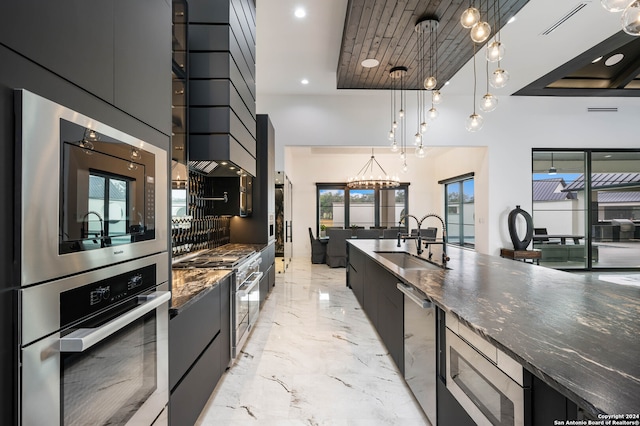 kitchen featuring pendant lighting, stainless steel appliances, sink, and a healthy amount of sunlight