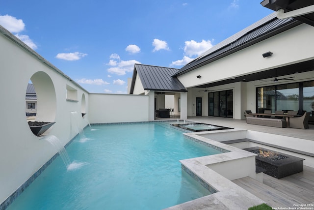 view of swimming pool with ceiling fan, a fire pit, a patio, an in ground hot tub, and pool water feature